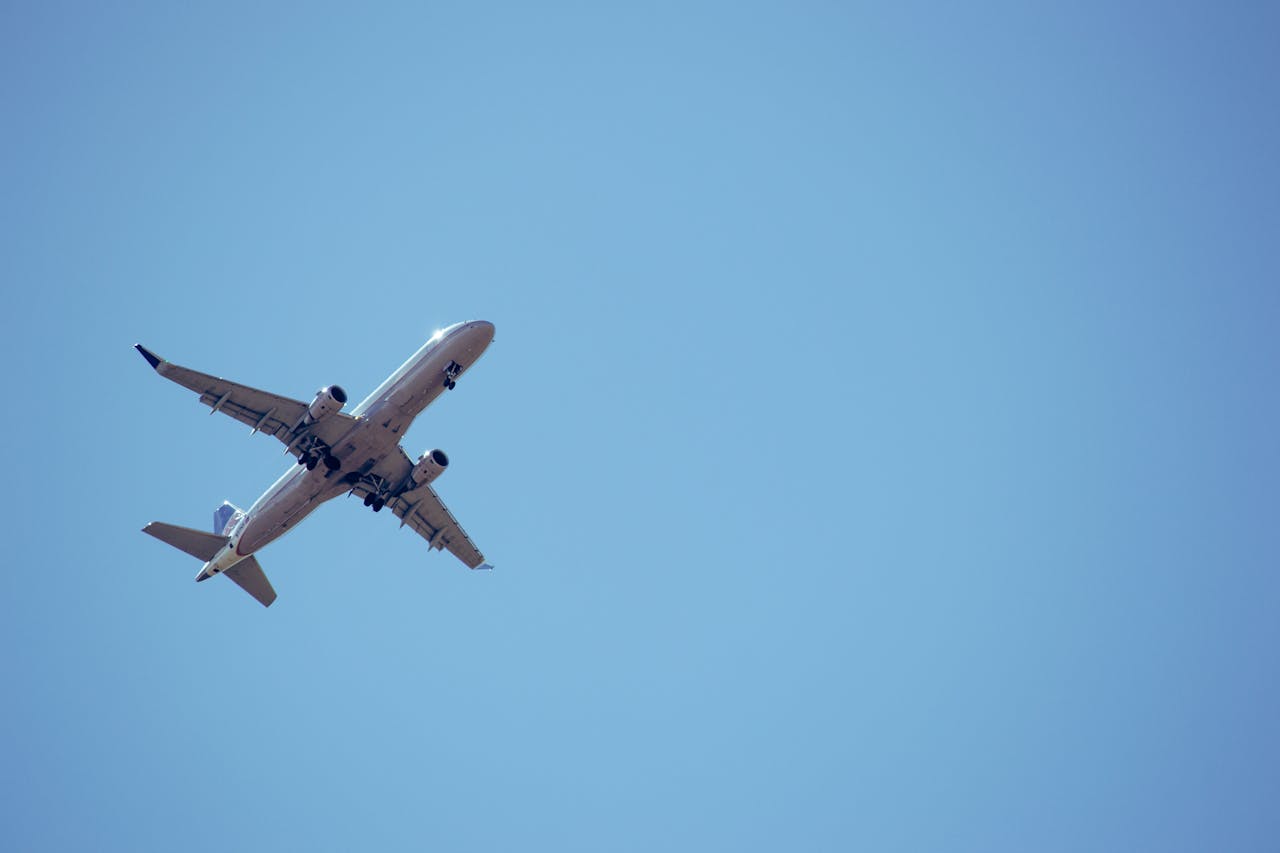 A commercial airplane captured mid-flight against a clear blue sky.